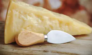 Un pezzo di Grana Padano, naturalmente privo di lattosio, pronto per essere gustato con il suo coltellino.