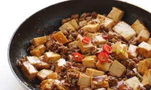 Tofu e lenticchie in padella, un piatto saporito con cubetti di tofu, carne macinata e peperoncino.