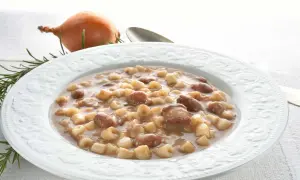 Piatto di pasta e fagioli borlotti, con cipolla e rosmarino sullo sfondo. Un comfort food che scalda il cuore.
