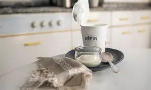 Kefir in un vasetto, pronto per una colazione chetogenica. Un cucchiaino e un tovagliolo completano la scena.