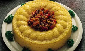 Sformatini di riso e verdure dorati, guarniti con un trito colorato e prezzemolo fresco.