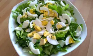 Insalata fresca con lattuga croccante e uova sode a spicchi, un contorno perfetto per ogni pasto.