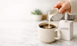 Versare latte di mandorla nel caffè, una scelta delicata per chi soffre di colon irritabile.