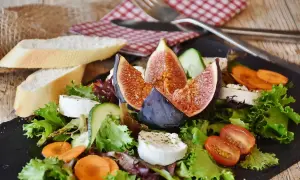 Insalata fresca con fichi, formaggio di capra e pane. Un'opzione leggera per chi soffre di colon irritabile, evitando gli spinaci.