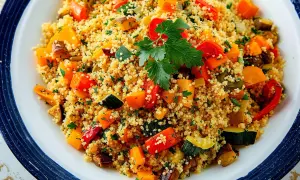Piatto di cous cous con verdure colorate, ideale per chi soffre di colon irritabile. Un pasto leggero e gustoso.