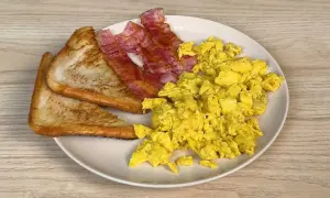 Piatto con uova strapazzate, bacon croccante e pane tostato. Un classico per iniziare la giornata con gusto.