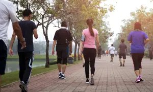 Persone che fanno una camminata metabolica in un parco, godendosi l'aria aperta e il movimento.