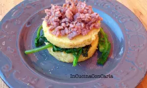 Polenta con cime di rapa e salsiccia sbriciolata, un piatto rustico e saporito.