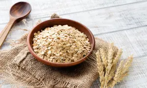 Ciotola di avena integrale, ricca di fibre e nutrienti, pronta per una colazione sana. Le sue proprietà la rendono un alimento ideale per il benessere.