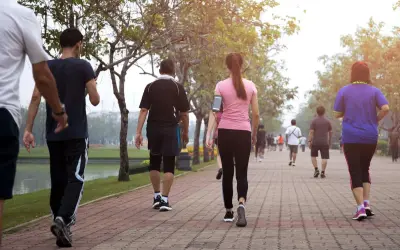 Persone che fanno una camminata metabolica in un parco, godendosi l'aria aperta e il movimento.