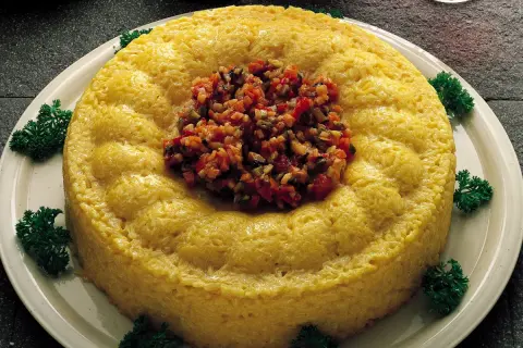 Sformatini di riso e verdure dorati, guarniti con un trito colorato e prezzemolo fresco.