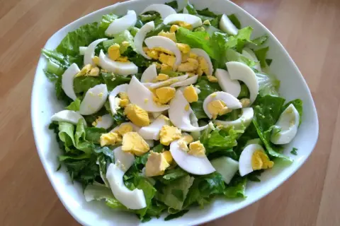 Insalata fresca con lattuga croccante e uova sode a spicchi, un contorno perfetto per ogni pasto.