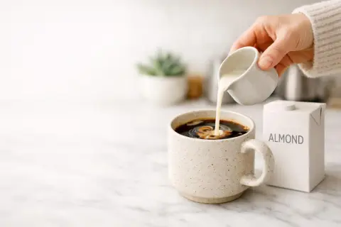 Versare latte di mandorla nel caffè, una scelta delicata per chi soffre di colon irritabile.
