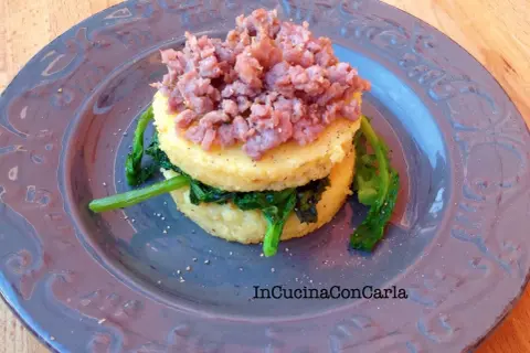 Polenta con cime di rapa e salsiccia sbriciolata, un piatto rustico e saporito.