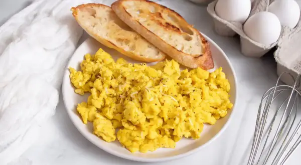 Uova strapazzate soffici con pane tostato, un'idea perfetta su cosa abbinare alle uova strapazzate per una colazione deliziosa.