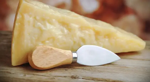 Un pezzo di Grana Padano, naturalmente privo di lattosio, pronto per essere gustato con il suo coltellino.
