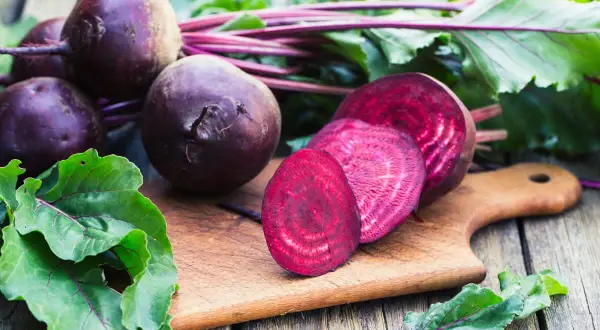 Barbabietola rossa, un alimento salutare per chi soffre di colon irritabile, tagliata su un tagliere di legno.