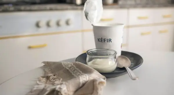 Kefir in un vasetto, pronto per una colazione chetogenica. Un cucchiaino e un tovagliolo completano la scena.