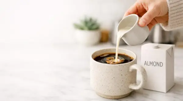 Versare latte di mandorla nel caffè, una scelta delicata per chi soffre di colon irritabile.