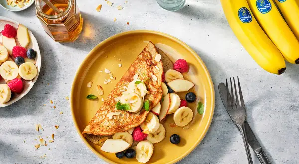 Crepe con banana, lamponi e mirtilli. Un piatto colorato che fa venire l'acquolina in bocca, ma attenzione: uova e banana fa male se non preparate bene!