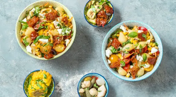 Insalate di pasta con pomodorini gialli, mais e feta, perfette per ricette primi estive.