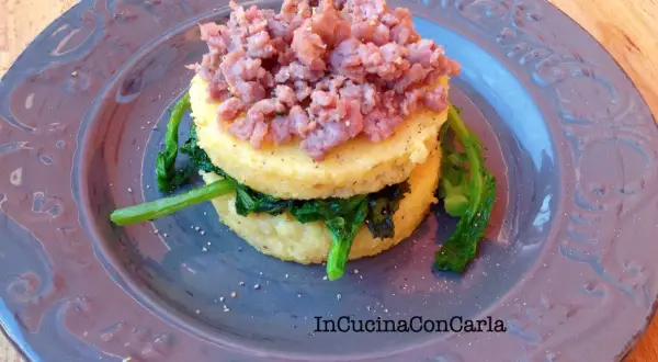 Polenta con cime di rapa e salsiccia sbriciolata, un piatto rustico e saporito.