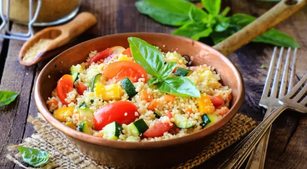 Cous cous integrale con verdure fresche: pomodori, zucchine, peperoni e carote. Un piatto leggero e salutare, ricco di fibre e vitamine.