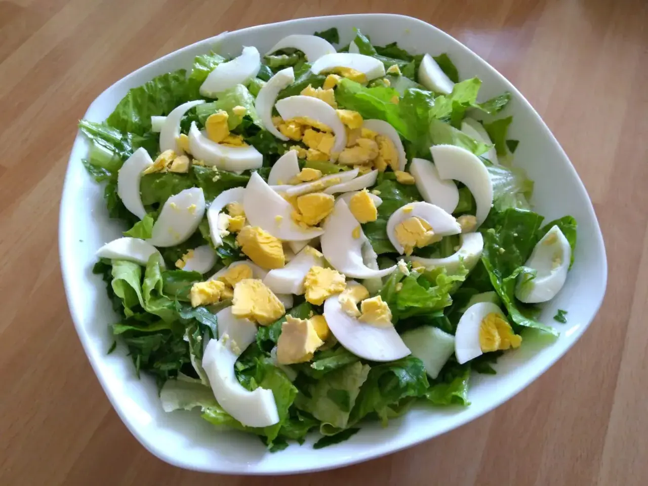 Insalata fresca con lattuga croccante e uova sode a spicchi, un contorno perfetto per ogni pasto.
