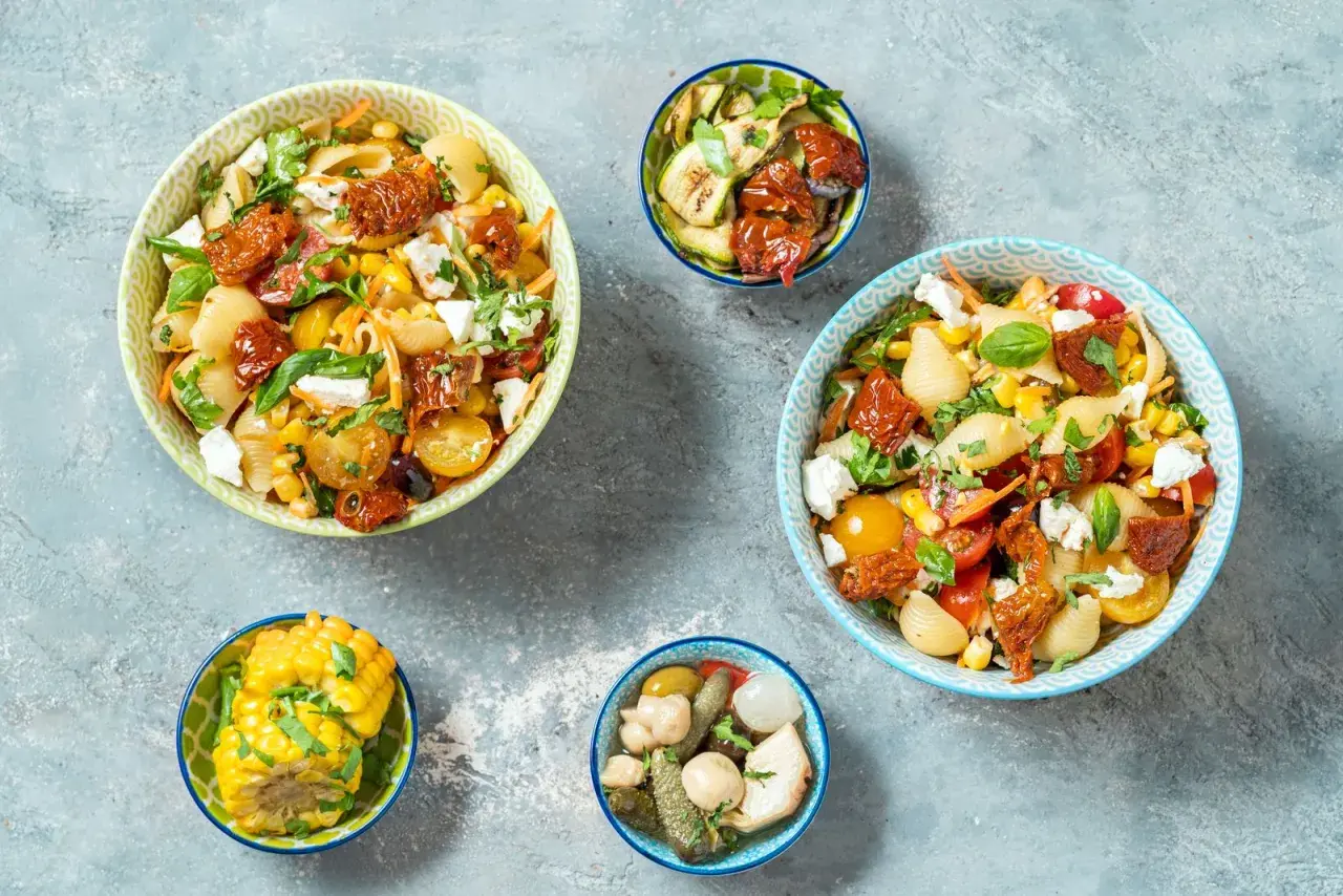 Insalate di pasta con pomodorini gialli, mais e feta, perfette per ricette primi estive.