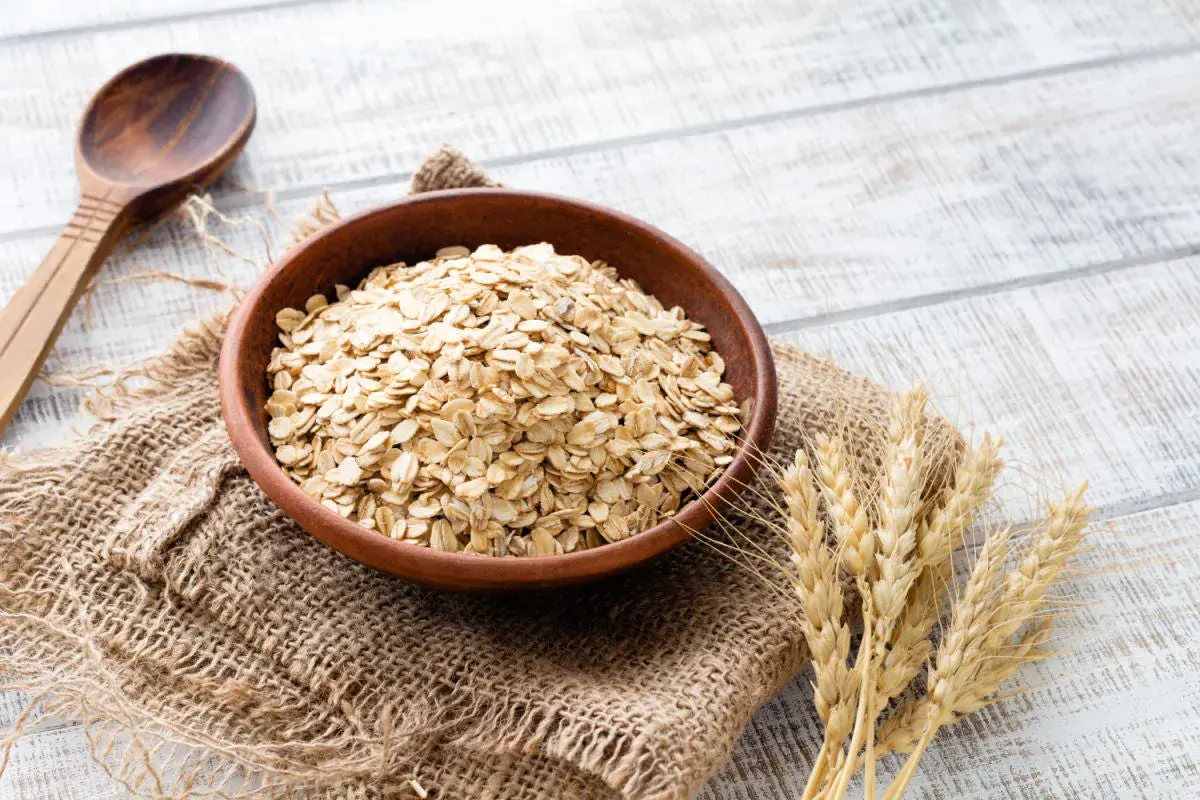 Ciotola di avena integrale, ricca di fibre e nutrienti, pronta per una colazione sana. Le sue proprietà la rendono un alimento ideale per il benessere.