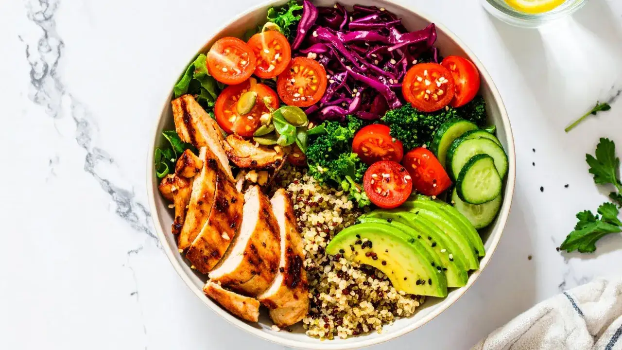 Insalata colorata con pollo grigliato, quinoa, avocado, pomodorini, cetrioli e cavolo rosso. Ideale per una dieta settimanale per glicemia alta.