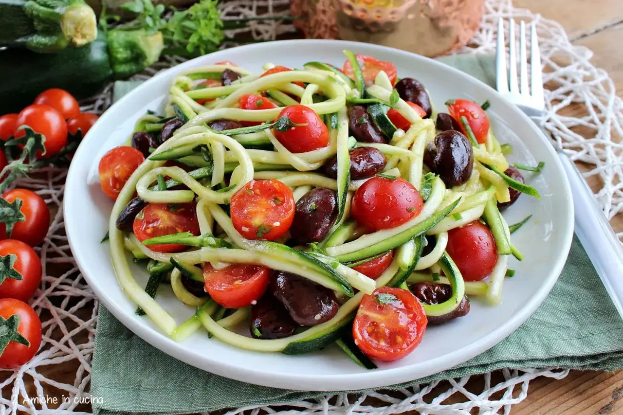 Spaghetti di zucchine con pomodorini e olive nere. Un piatto fresco e leggero, perfetto per l'estate.