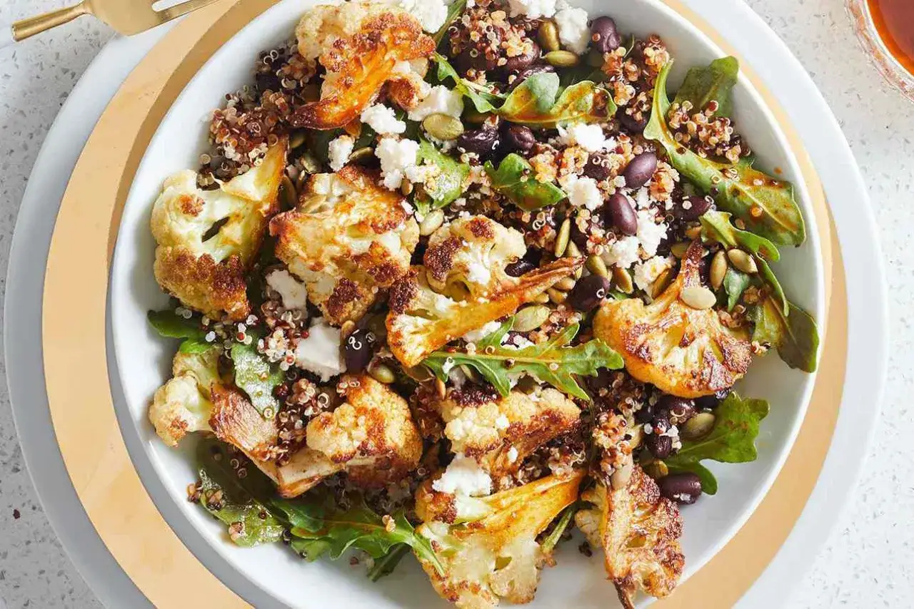 Insalata colorata con cavolfiore arrosto, fagioli neri, semi e formaggio. Attenzione, la quinoa gonfia la pancia!