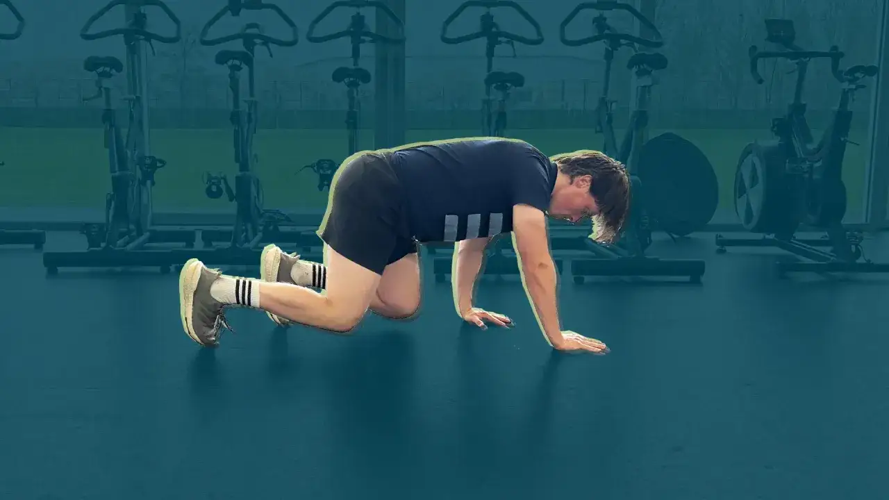 Ragazzo in posizione di quadrupedia, pratica animal flow in palestra.