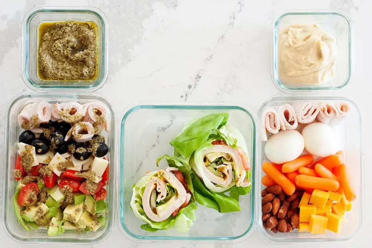 Pasti per la dieta low carb: insalata, involtini di lattuga, uova sode, carote, formaggio, mandorle e hummus.