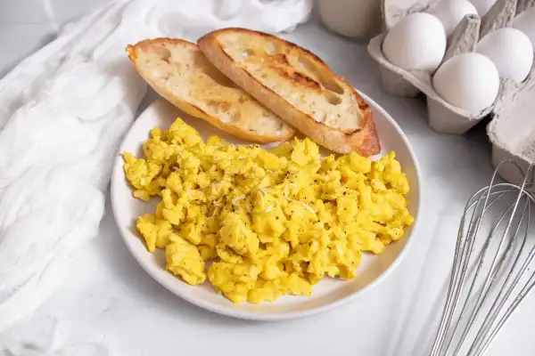 Uova strapazzate soffici con pane tostato, un'idea perfetta su cosa abbinare alle uova strapazzate per una colazione deliziosa.