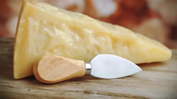 Un pezzo di Grana Padano, naturalmente privo di lattosio, pronto per essere gustato con il suo coltellino.