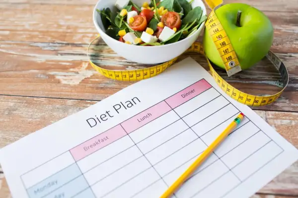 Piano alimentare con mela verde, insalata e metro, per una dieta facile da seguire.