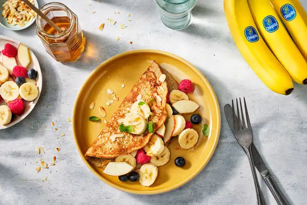 Crepe con banana, lamponi e mirtilli. Un piatto colorato che fa venire l'acquolina in bocca, ma attenzione: uova e banana fa male se non preparate bene!