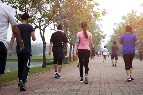 Persone che fanno una camminata metabolica in un parco, godendosi l'aria aperta e il movimento.