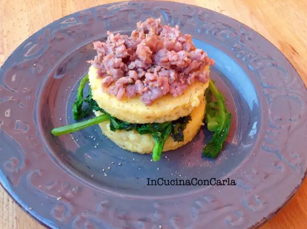 Polenta con cime di rapa e salsiccia sbriciolata, un piatto rustico e saporito.